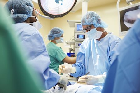 Surgeons performing a weight loss procedure to help illustrate Surgeons performing a procedure in a room to help illustrate Weight Loss Surgery vs. Medication